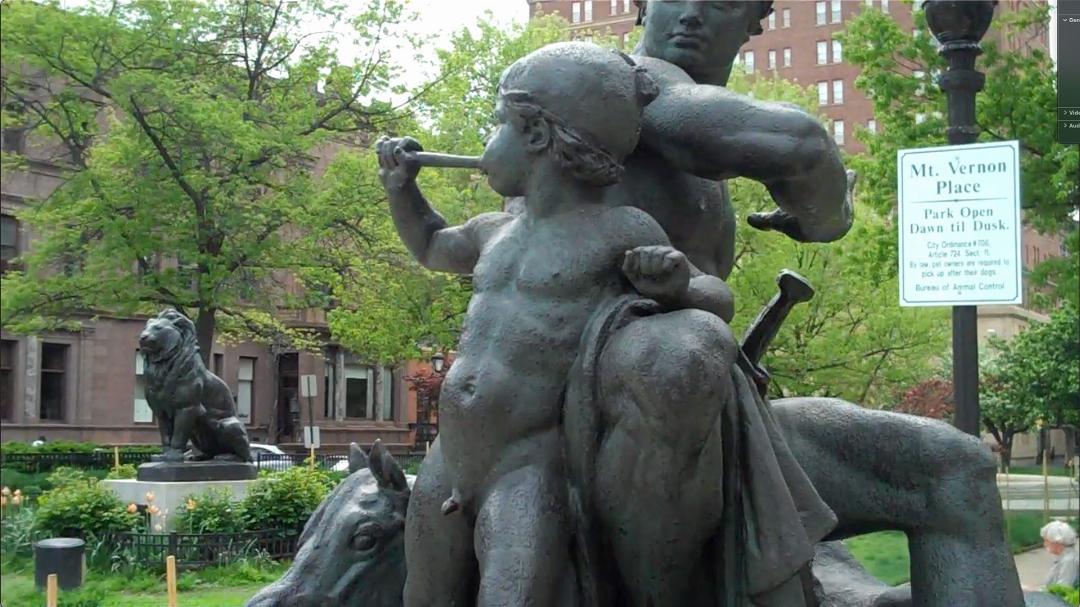 Bronze sculpture of a child and a man located in Baltimore City, MD.